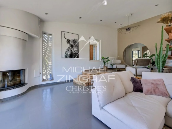 Interior of a bright house with a modern living room and a fireplace.