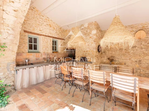 Interior of a renovated kitchen with stone walls and a large wooden table.