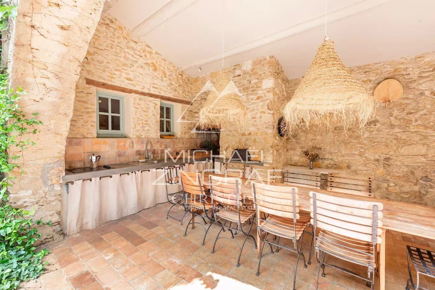 Cuisine rénovée de la magnanerie Intérieur d'une cuisine rénovée avec des murs en pierre et une grande table en bois.