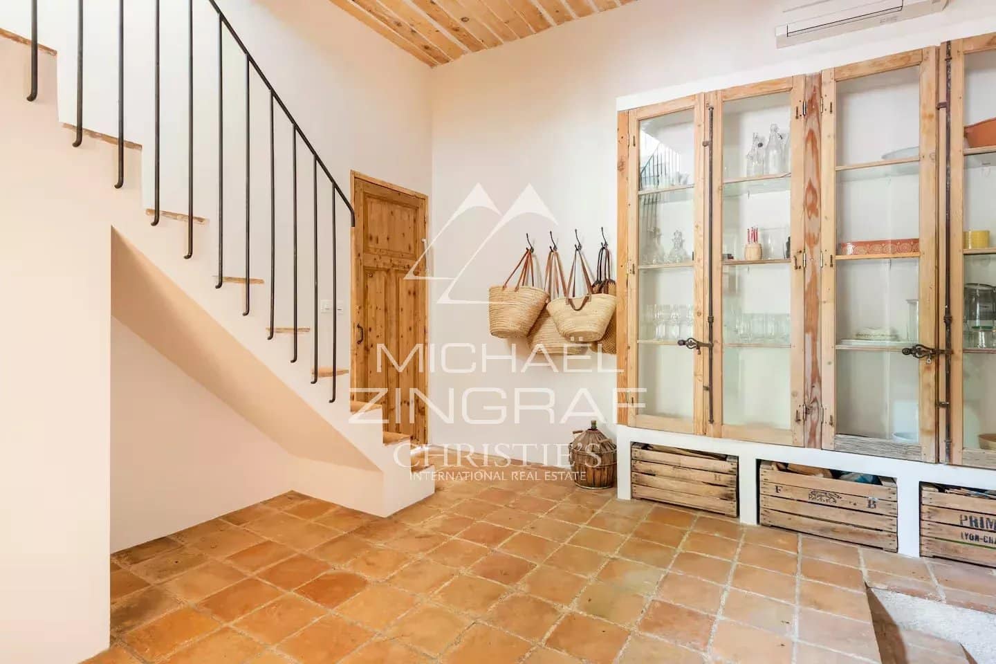 Intérieur d’une magnanerie rénovée Intérieur d'une magnanerie rénovée avec un escalier et des étagères en bois.