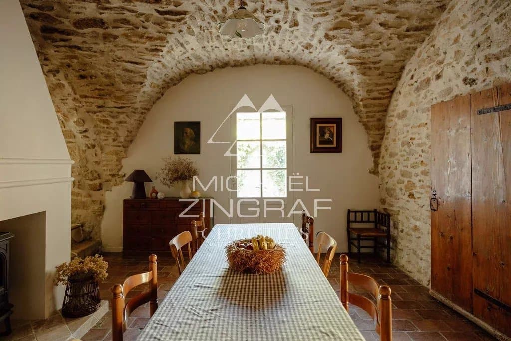 Intérieur de la magnanerie rénovée Intérieur d'une magnanerie rénovée avec des murs en pierre et une table en bois