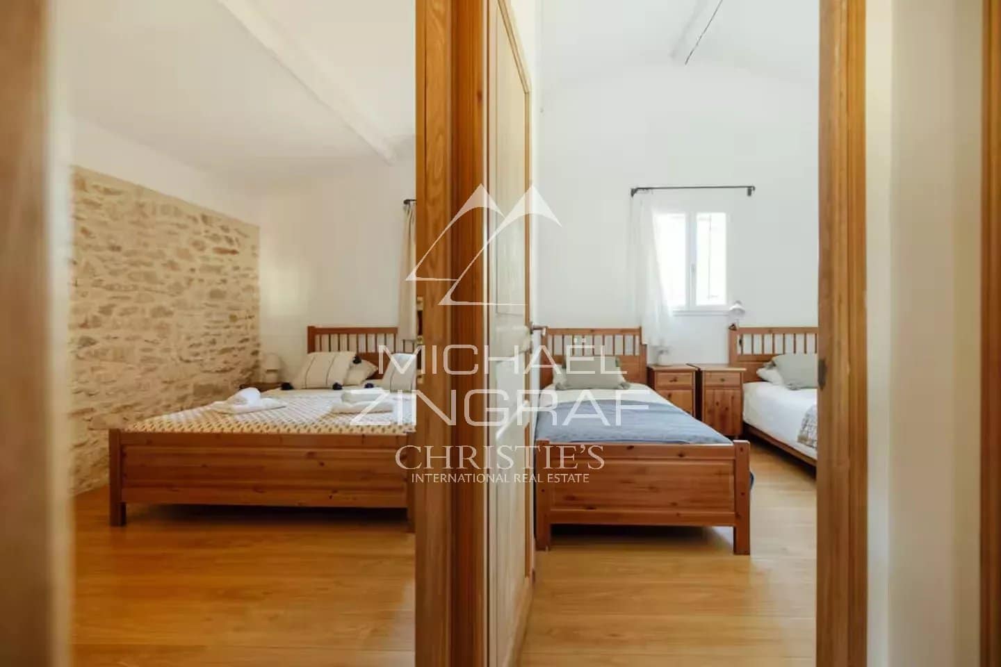 Chambre de magnanerie rénovée Chambre d'une magnanerie rénovée avec lits en bois et murs en pierre apparente.