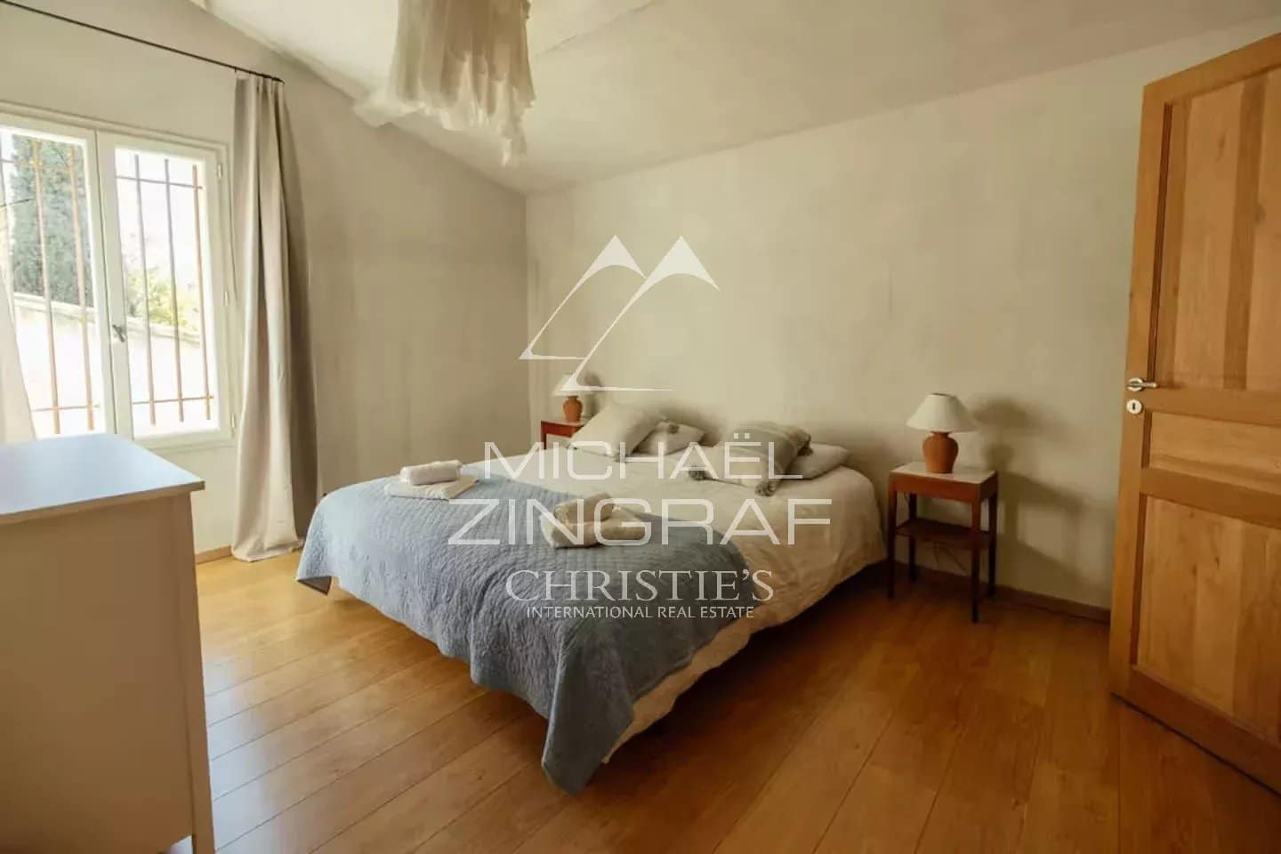 Chambre d’une magnanerie rénovée Chambre d'une magnanerie rénovée avec lit double et fenêtres lumineuses.