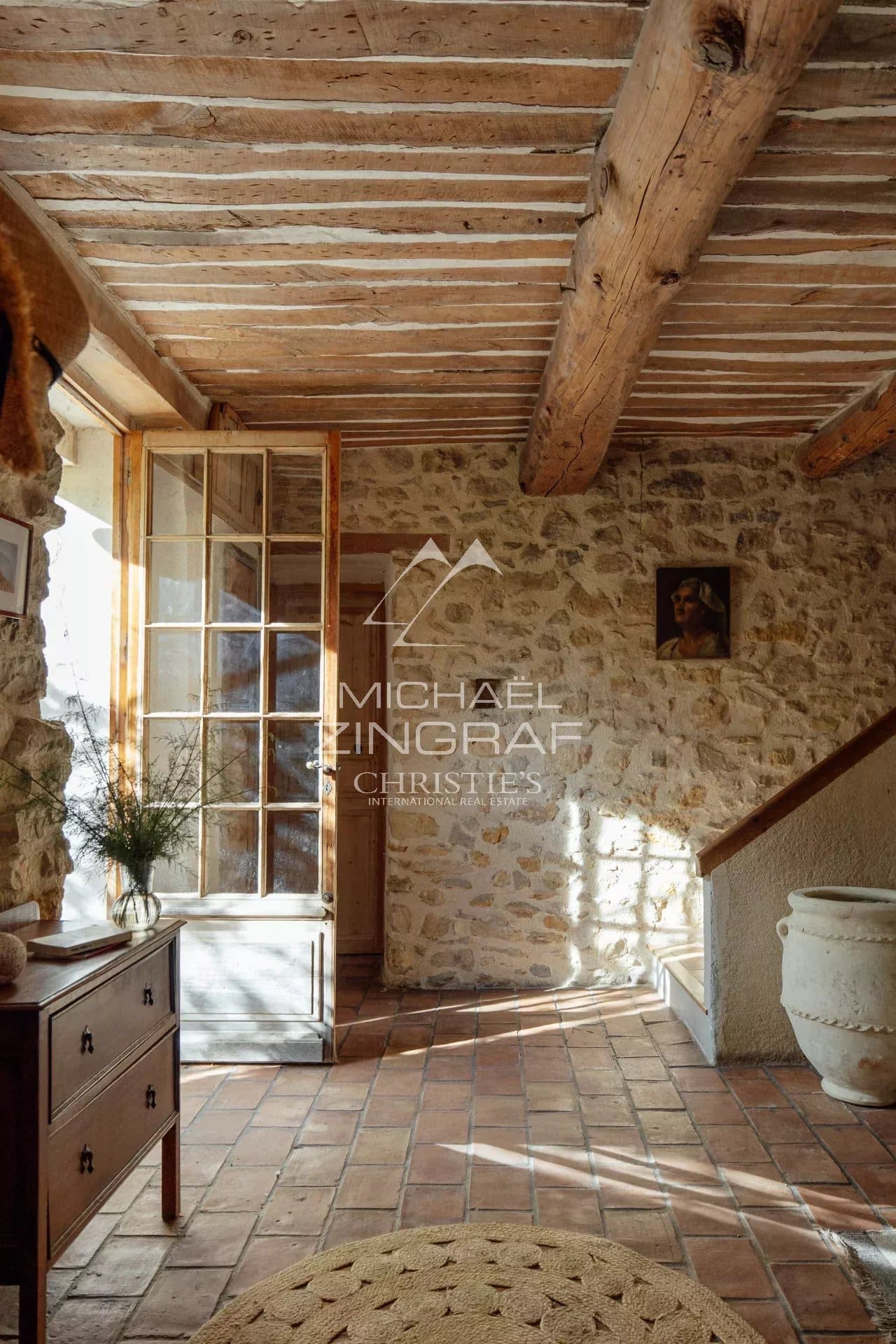 Intérieur d’une magnanerie rénovée Intérieur lumineux d'une magnanerie rénovée avec des murs en pierre et des poutres en bois.