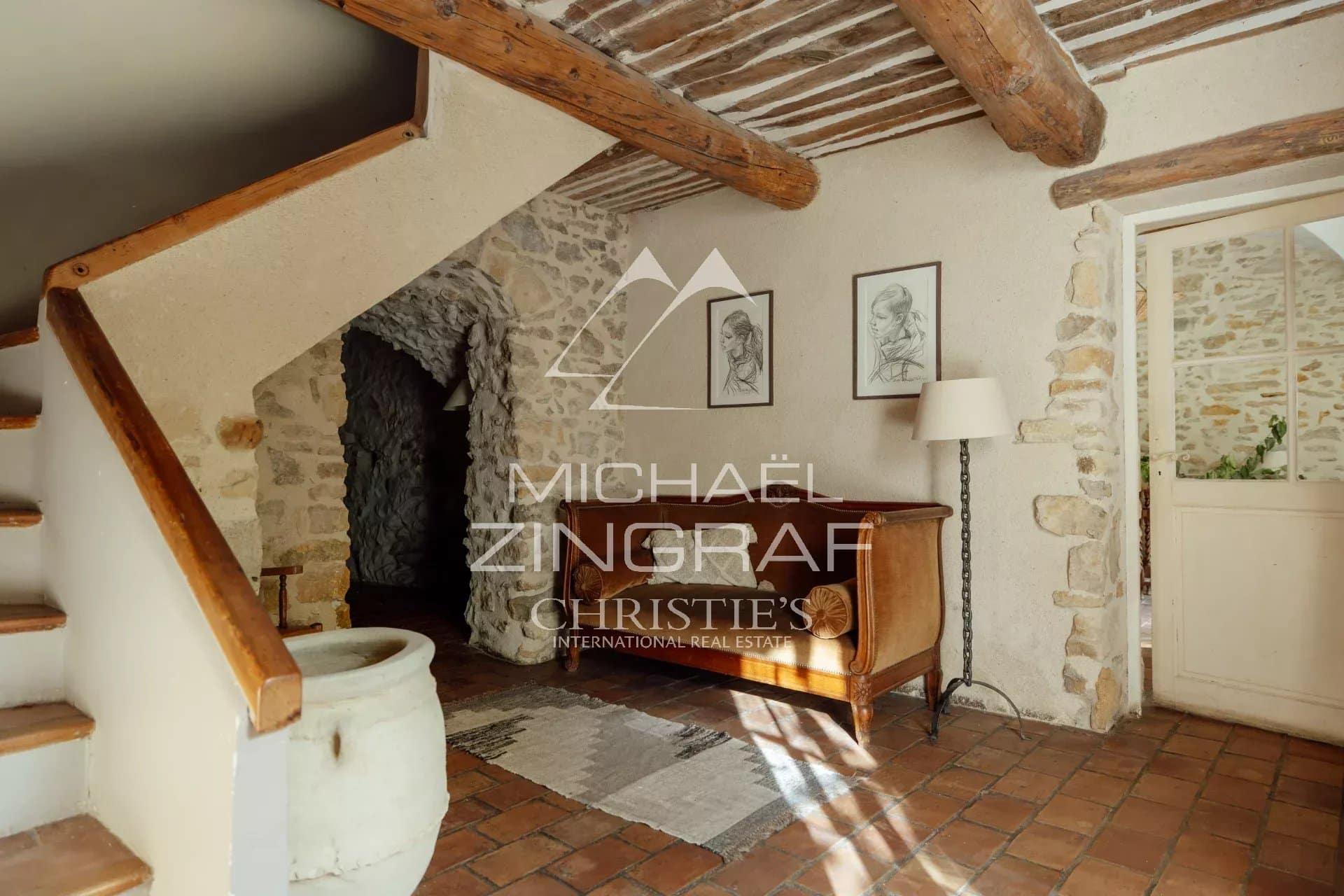 Intérieur de la magnanerie rénovée Intérieur d'une magnanerie rénovée avec des murs en pierre et un escalier en bois.