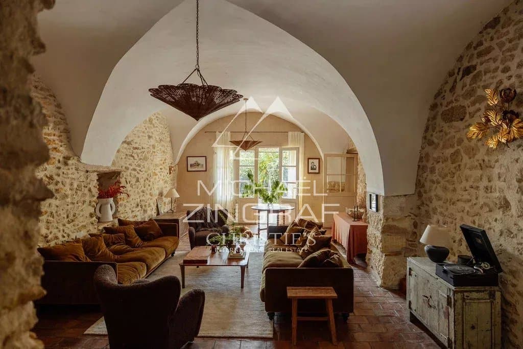 Intérieur d’une magnanerie rénovée Intérieur d'une magnanerie rénovée avec un salon spacieux et des murs en pierre apparente.