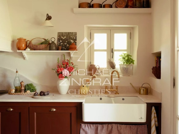 Cuisine moderne avec évier en céramique et décor provençal, éléments en bois et plantes.