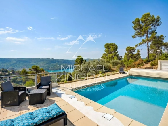 Panoramic view of Lake Esparron with swimming pool and green landscape in the background.