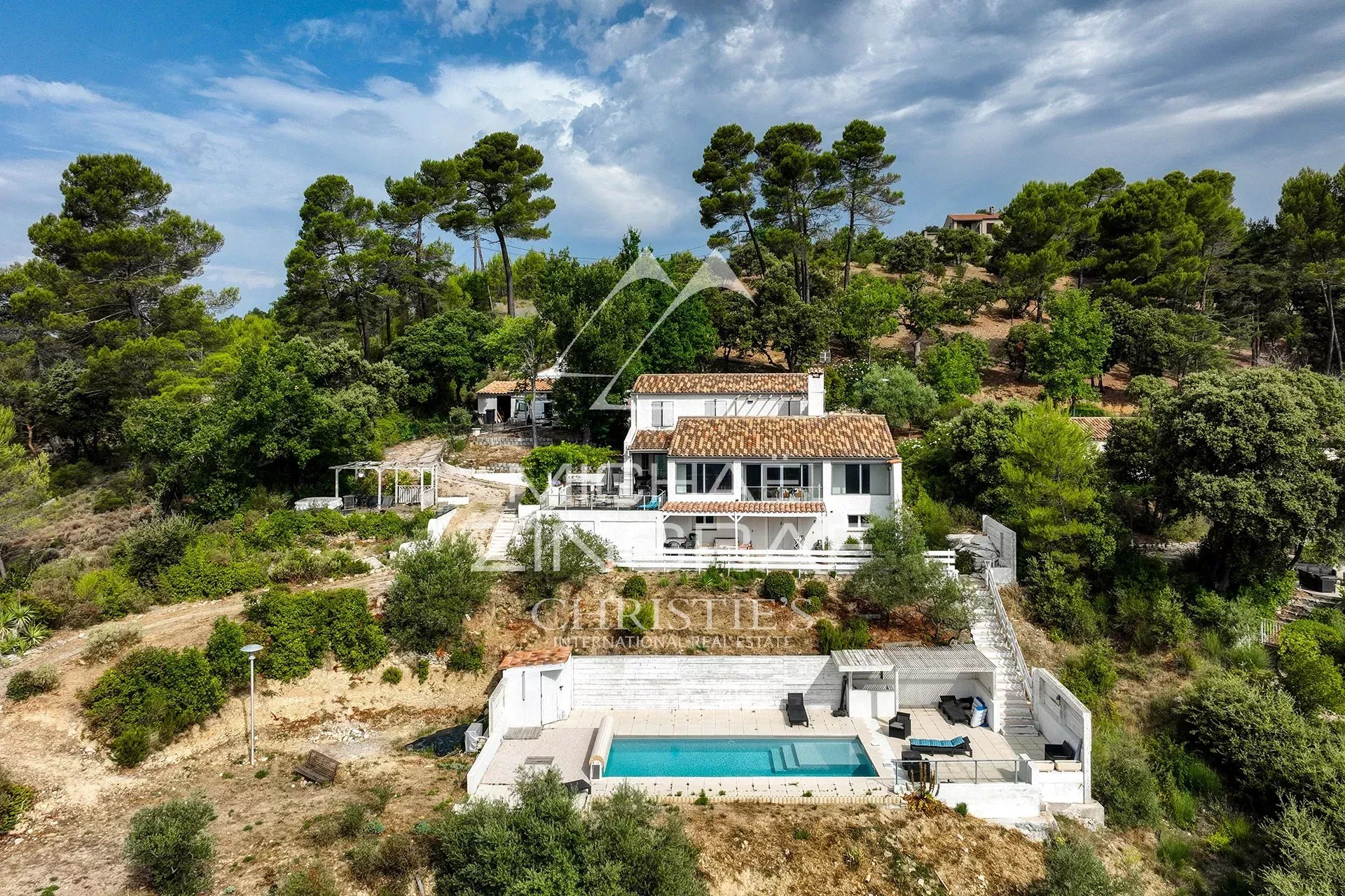 Panoramic view of a property with swimming pool and vegetation, near Lake Esparron-de-Verdon.