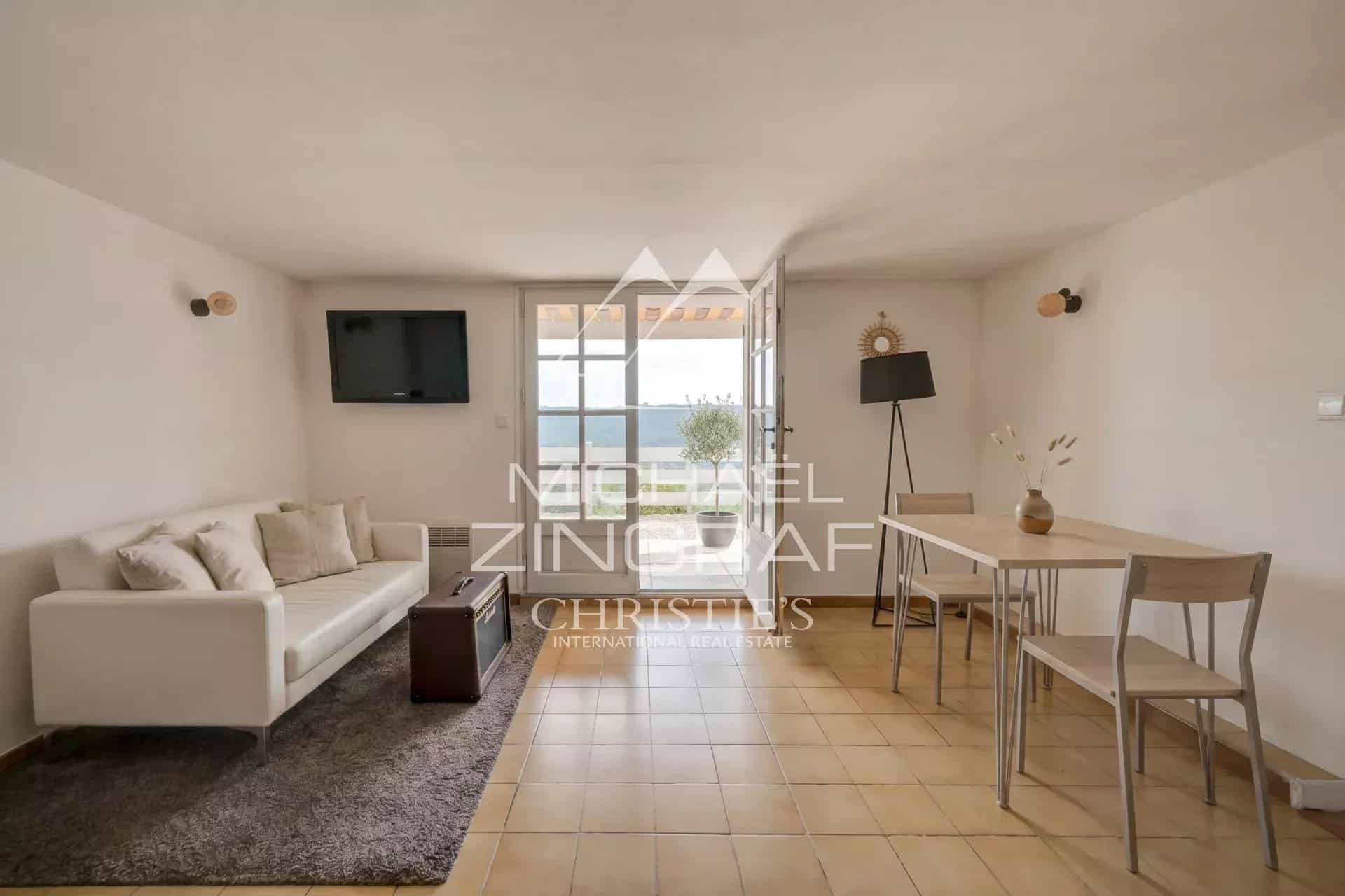 Interior of a property with living room and dining room, overlooking Lake Esparron.