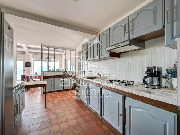 Spacious kitchen with wooden furniture and tiled floor, overlooking Lake Esparron.