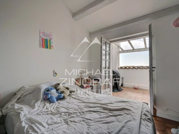 Room with bed and access to a balcony, simply decorated.