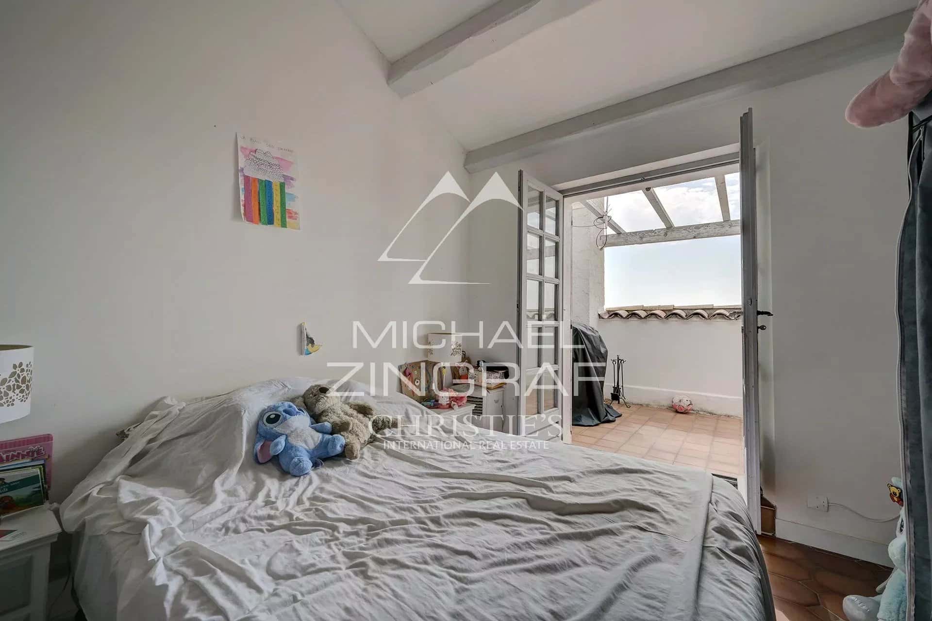 Room with bed and access to a balcony, simply decorated.
