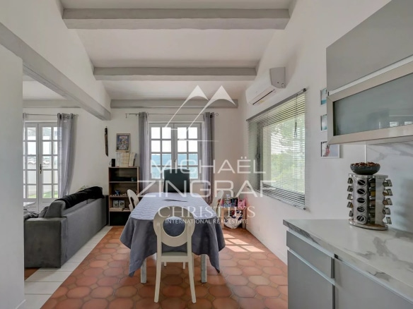 Interior of a house with dining room and living room, view of the outside.