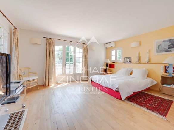 Chambre lumineuse avec fenêtres et mobilier moderne, vue sur l'extérieur.