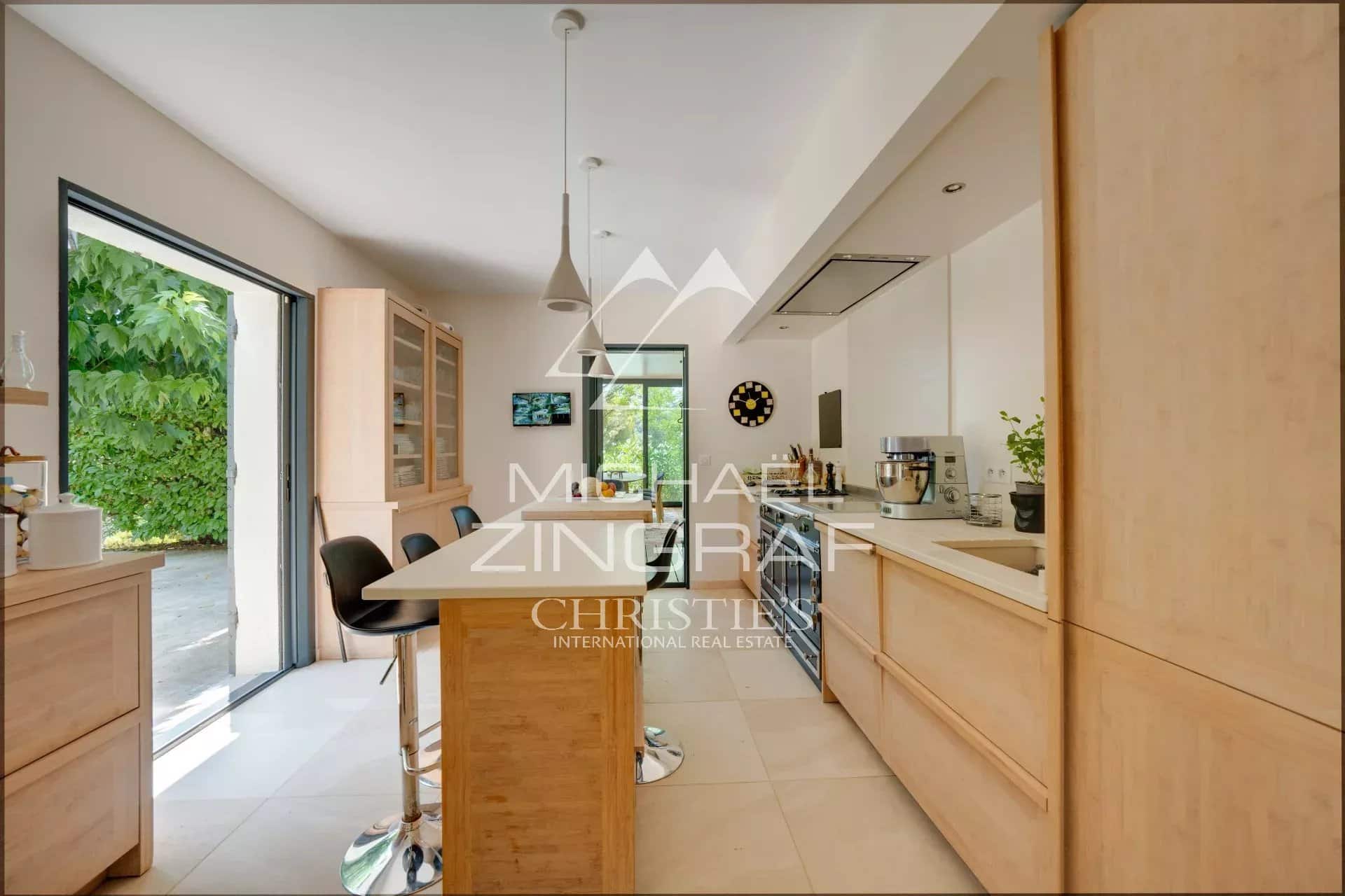 Modern and bright kitchen with bar, open to the outside in a property in Aix-en-Provence.
