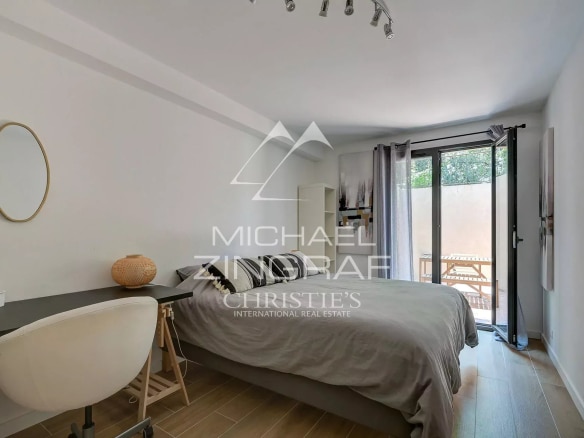 Modern room with double bed, desk and access to a balcony.