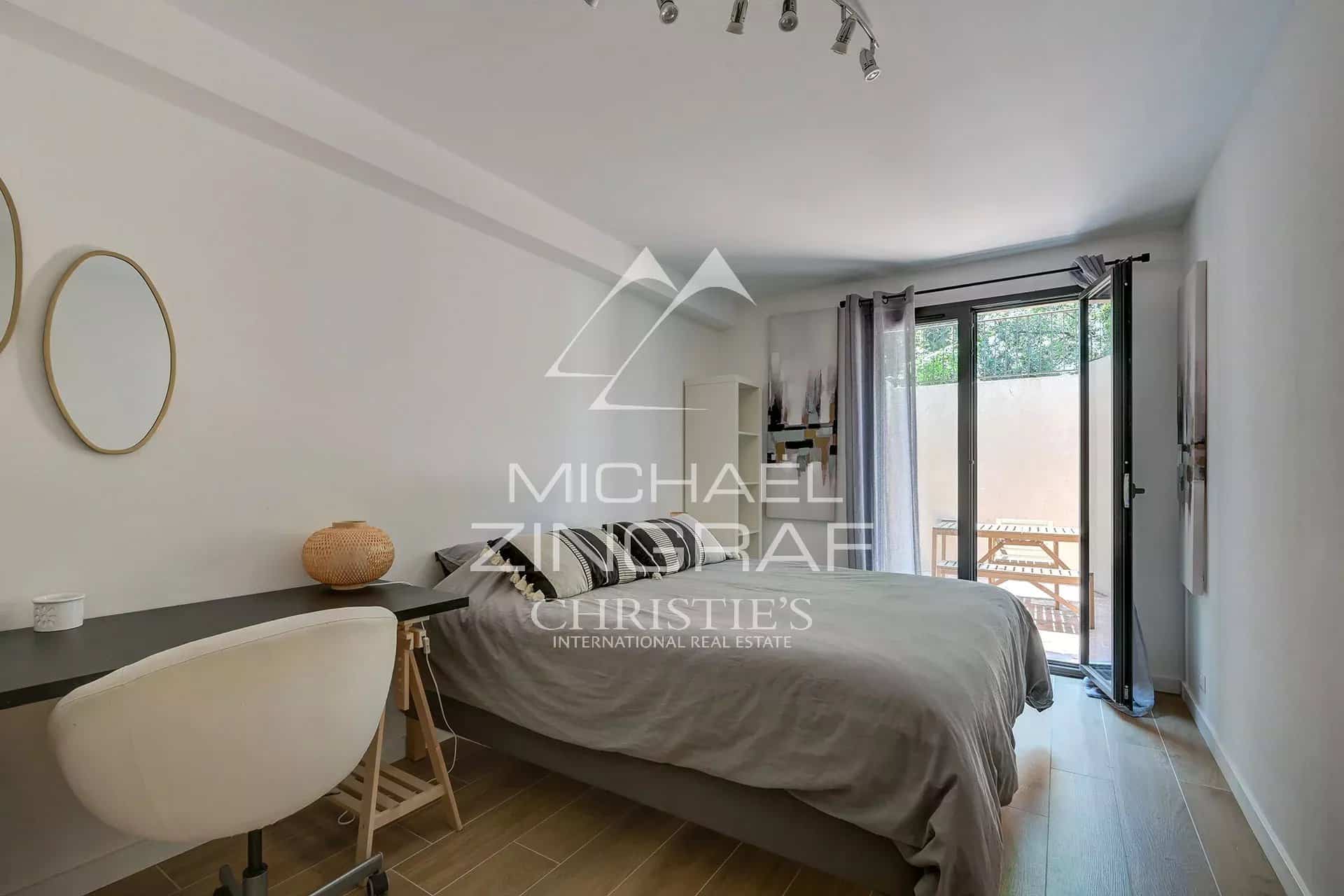Modern room with double bed, desk and access to a balcony.