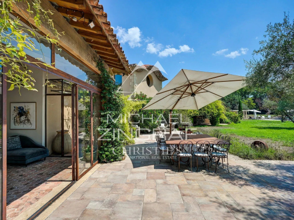 Terrace of a property with table and chairs, surrounded by greenery in Aix-en-Provence.