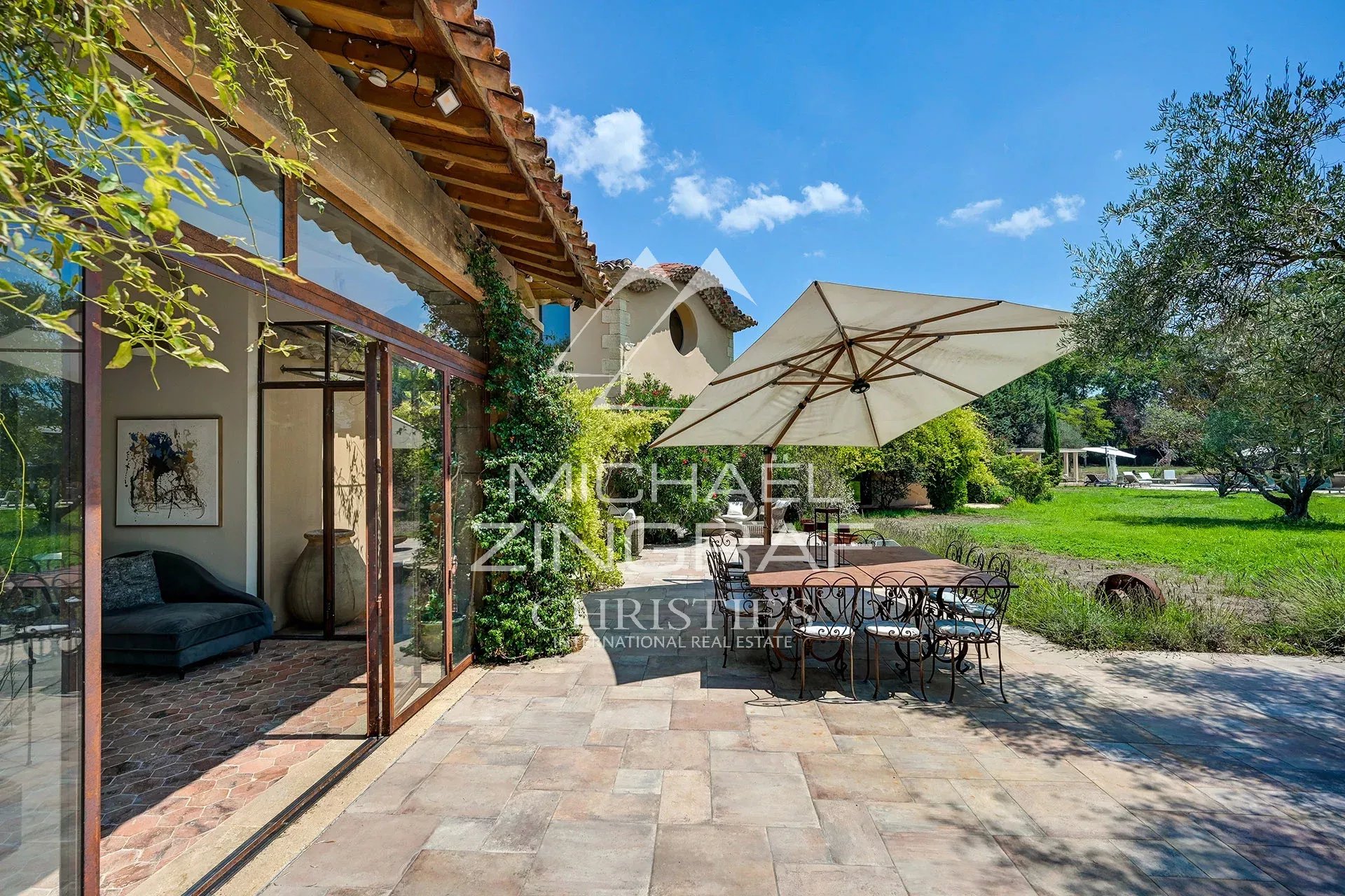 Terrace of a property with table and chairs, surrounded by greenery in Aix-en-Provence.