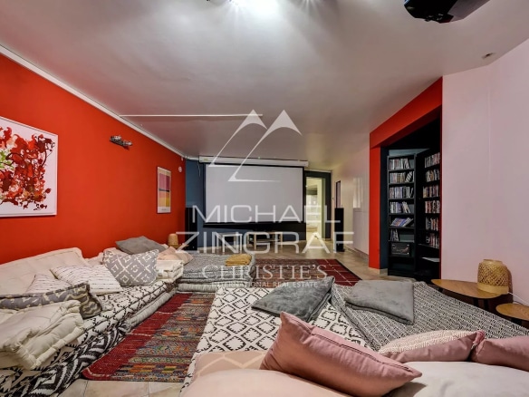 Spacious living room with red walls and rug, comfortable furniture, soft lighting.