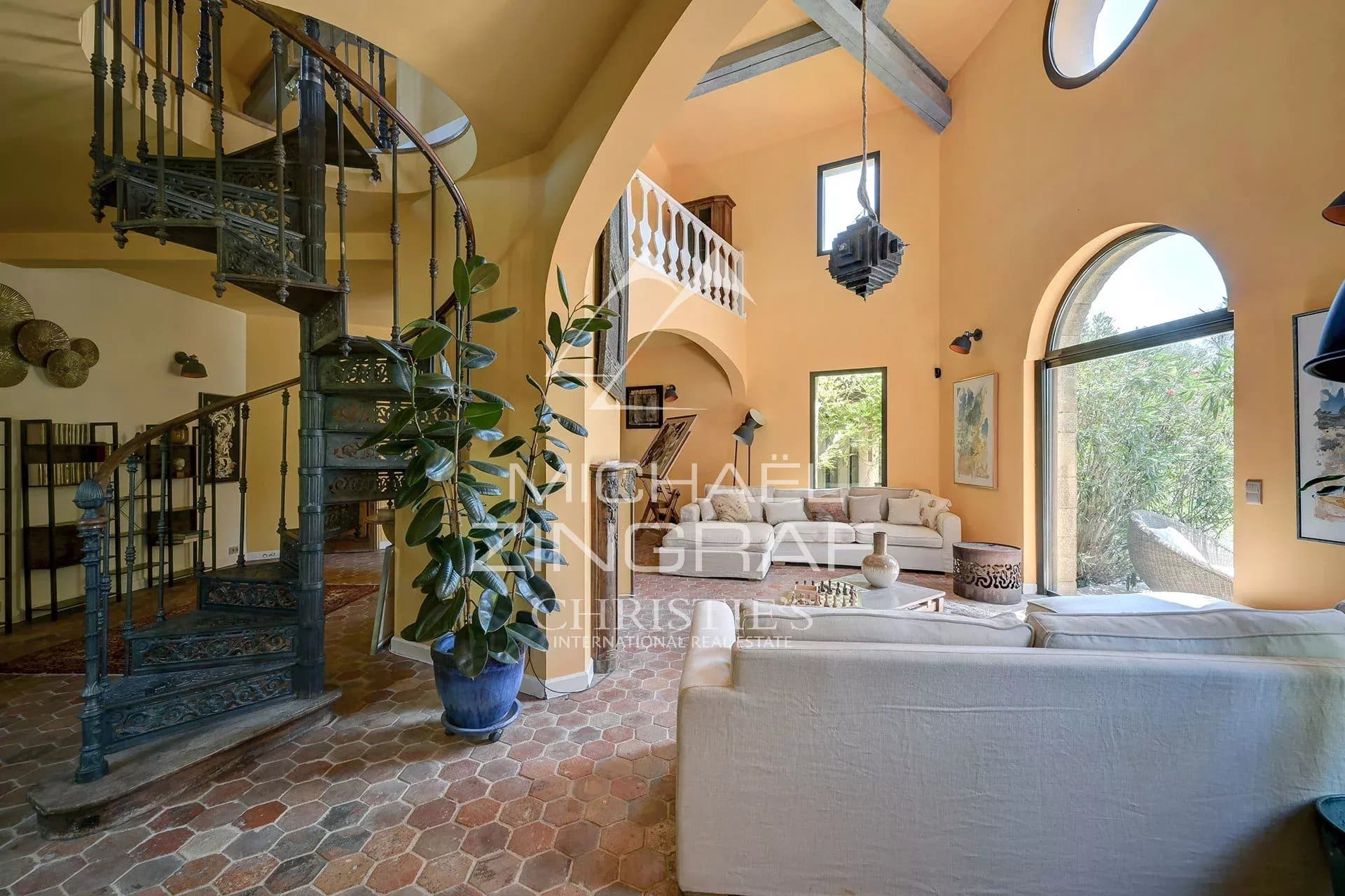 Interior of a luxury property with a spiral staircase and a bright living room in Aix-en-Provence.