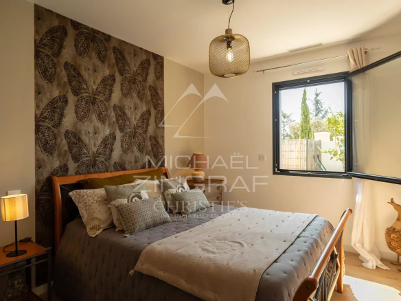 Bedroom in a contemporary property with walls decorated with butterfly motifs and an open window.