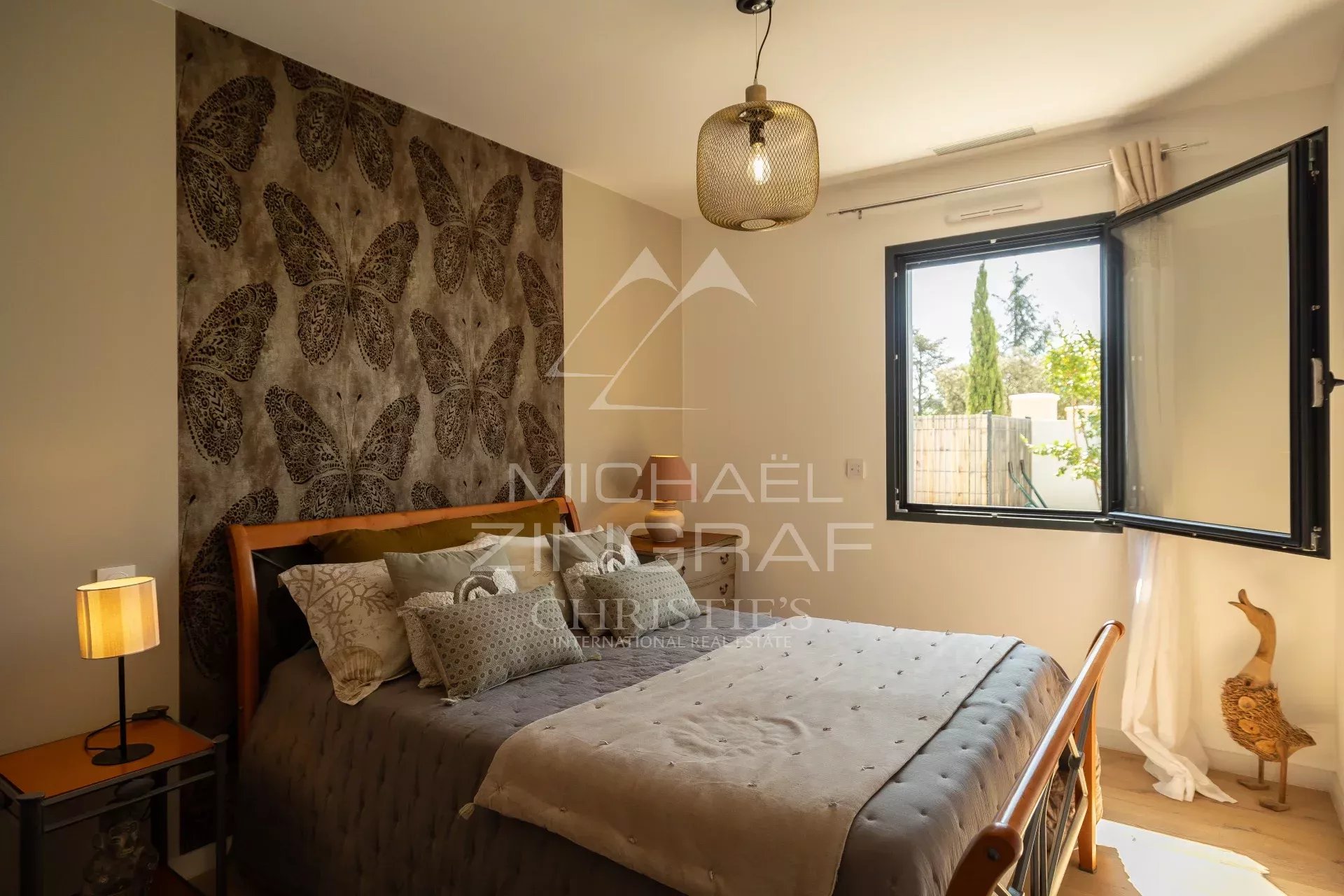 Modern bedroom with elegant decor Bedroom in a contemporary property with walls decorated with butterfly motifs and an open window.