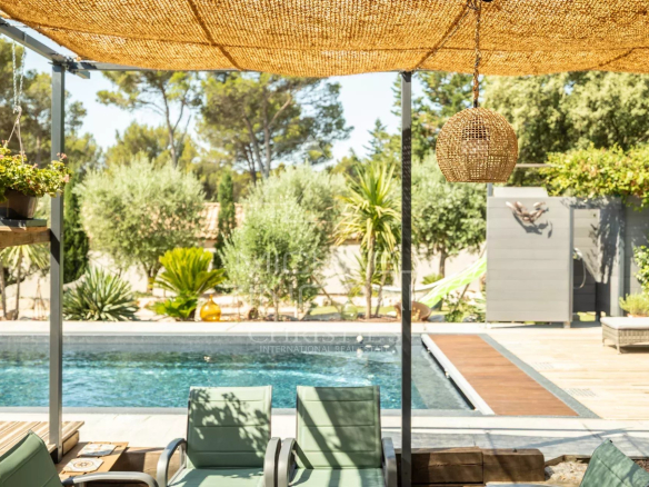 View of the pool and terrace of a contemporary property in Puget, with surrounding plants.