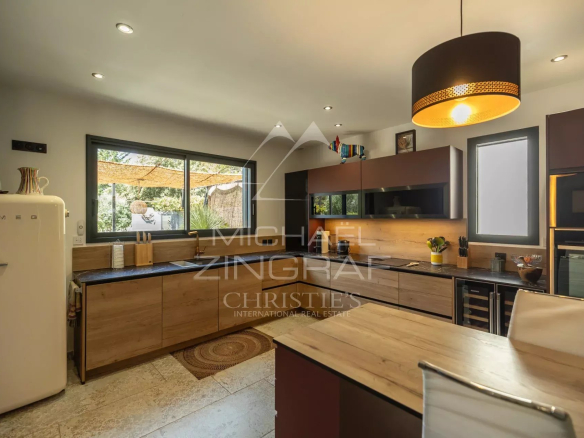 Modern and spacious kitchen in a contemporary property in Puget, with wooden elements and bright windows.