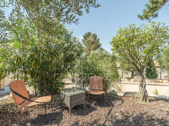 Outdoor space of a contemporary property in Puget with chairs and a table in the middle of greenery.