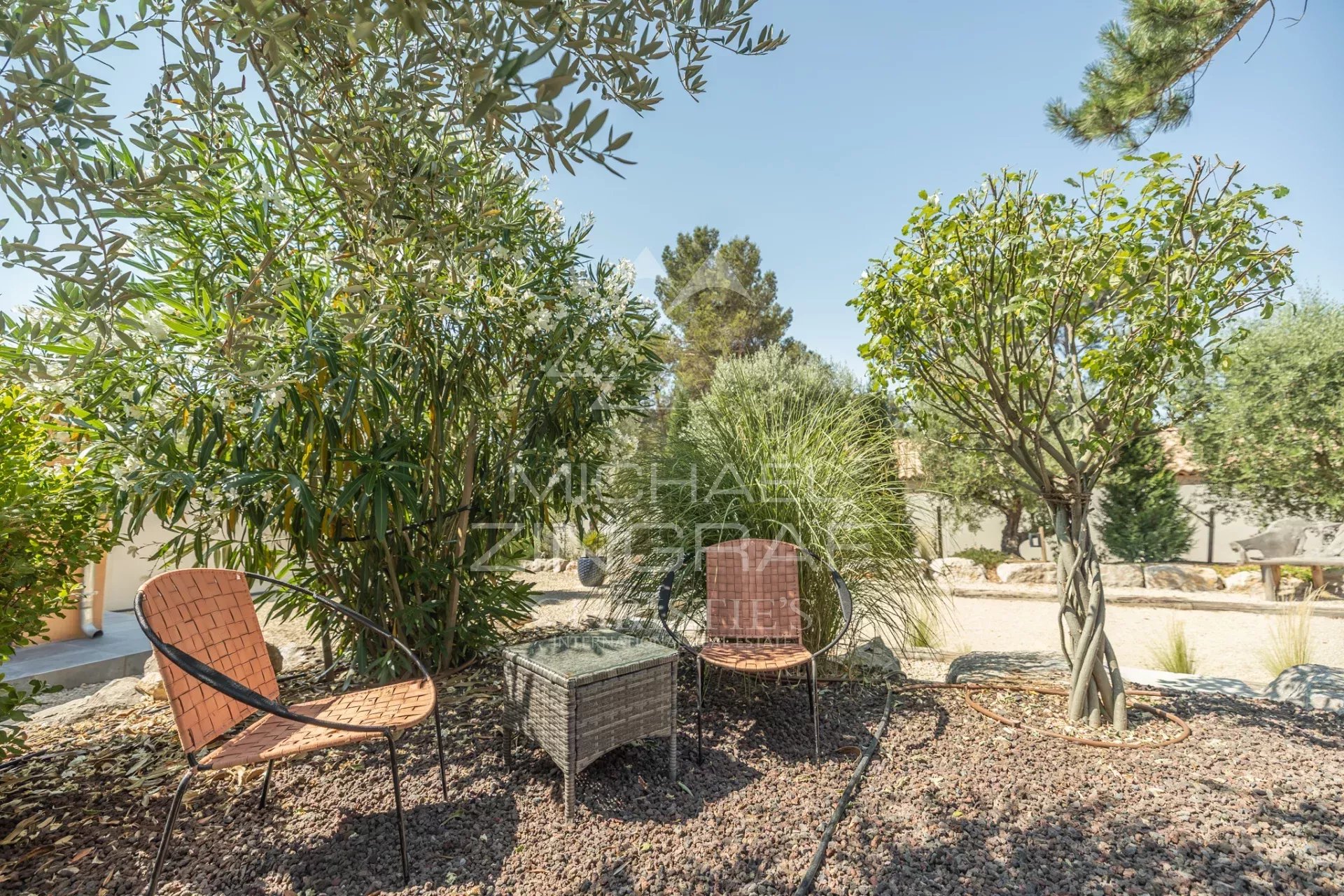 Outdoor space of a contemporary property Outdoor space of a contemporary property in Puget with chairs and a table in the middle of greenery.