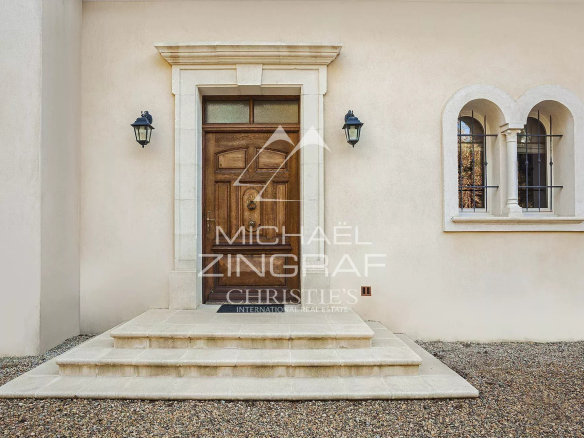 Entrance to a 19th-century bourgeois property with stairs and a wooden door.