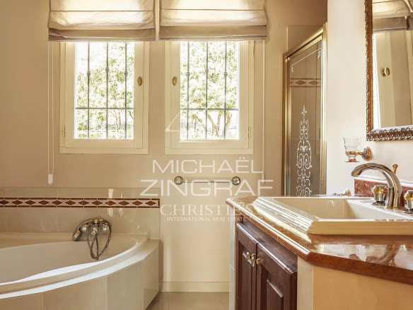 Elegant bathroom with bathtub and window letting in light.
