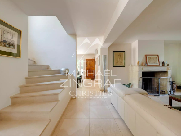 Interior of a property in Aix-en-Provence with a bright living room and marble staircase.