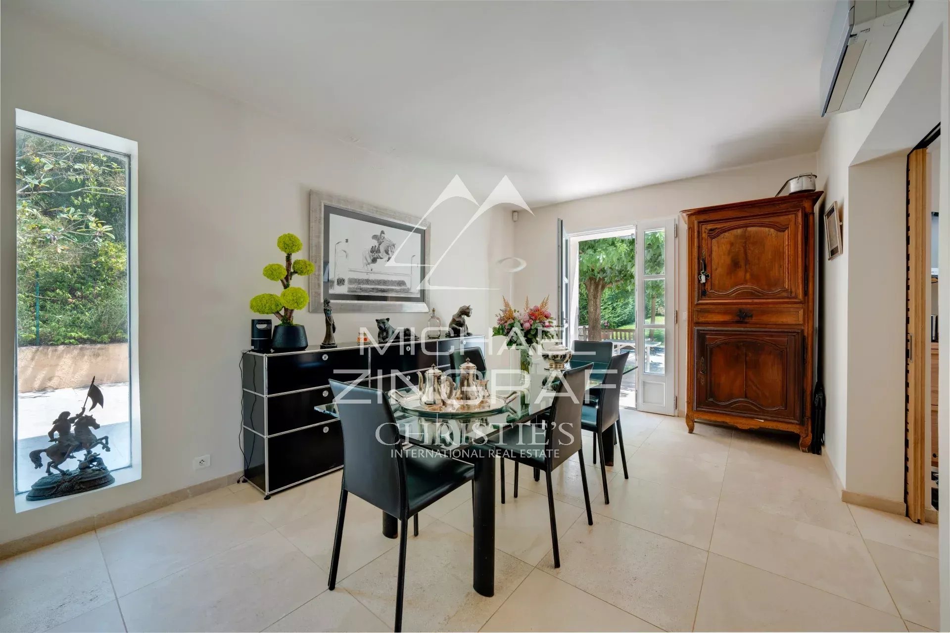Dining room of a property in Aix-en-Provence Dining room of an elegant property with access to a terrace, surrounded by greenery.
