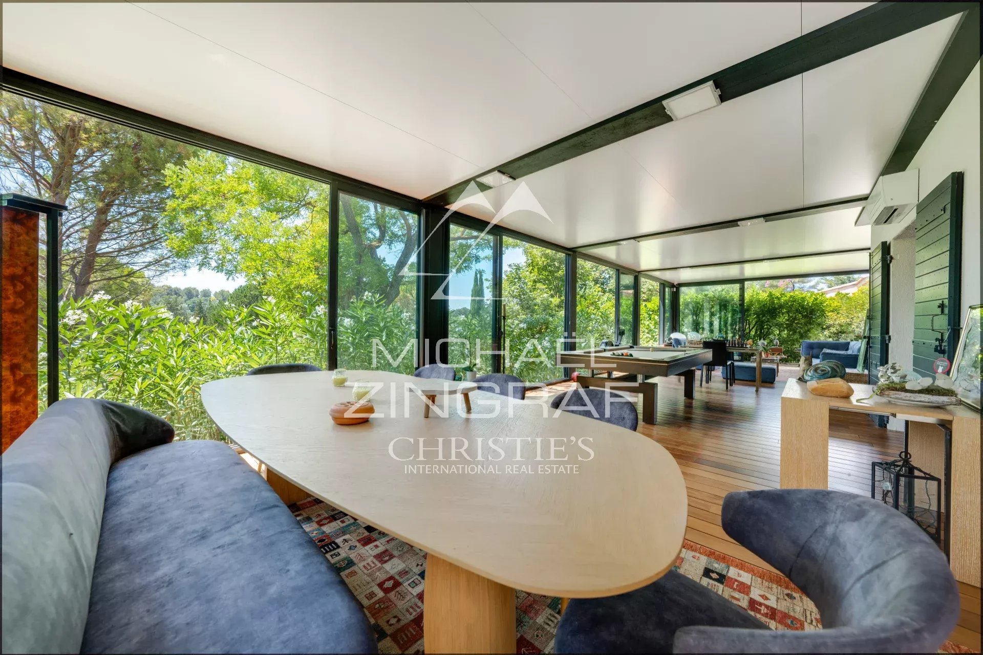 Interior of a property in Aix-en-Provence Interior of a property in Aix-en-Provence with a large table and windows overlooking greenery.