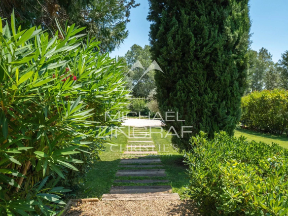 A verdant driveway leading to a property in a landscaped park in Aix-en-Provence.