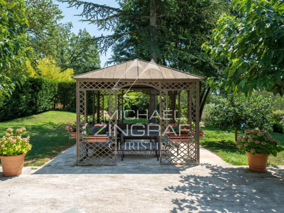 Wooden garden shed in a landscaped park with flowers and trees in Aix-en-Provence.