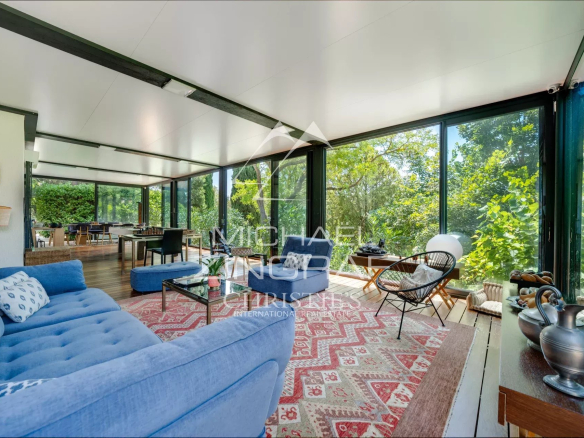 Interior of a property in Aix-en-Provence with a bright living room and large bay windows.