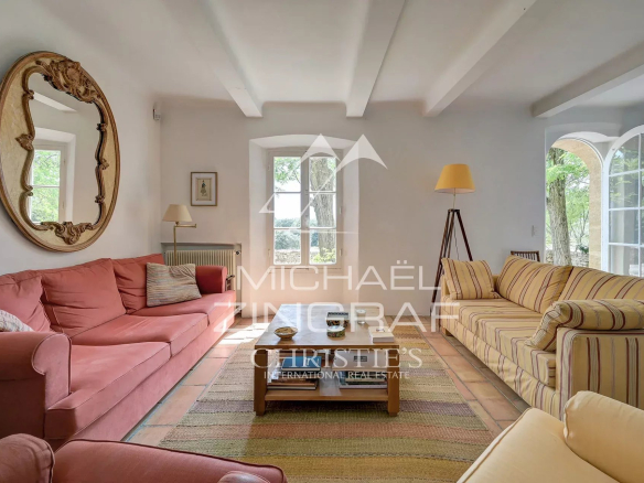 Interior of a 19th century Provençal country house with a bright living room and comfortable furniture.