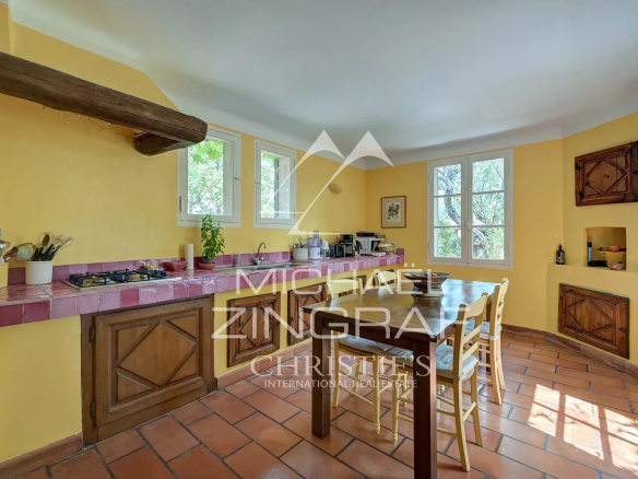 Kitchen of a Provençal country house with yellow walls and a wooden table, Jouques