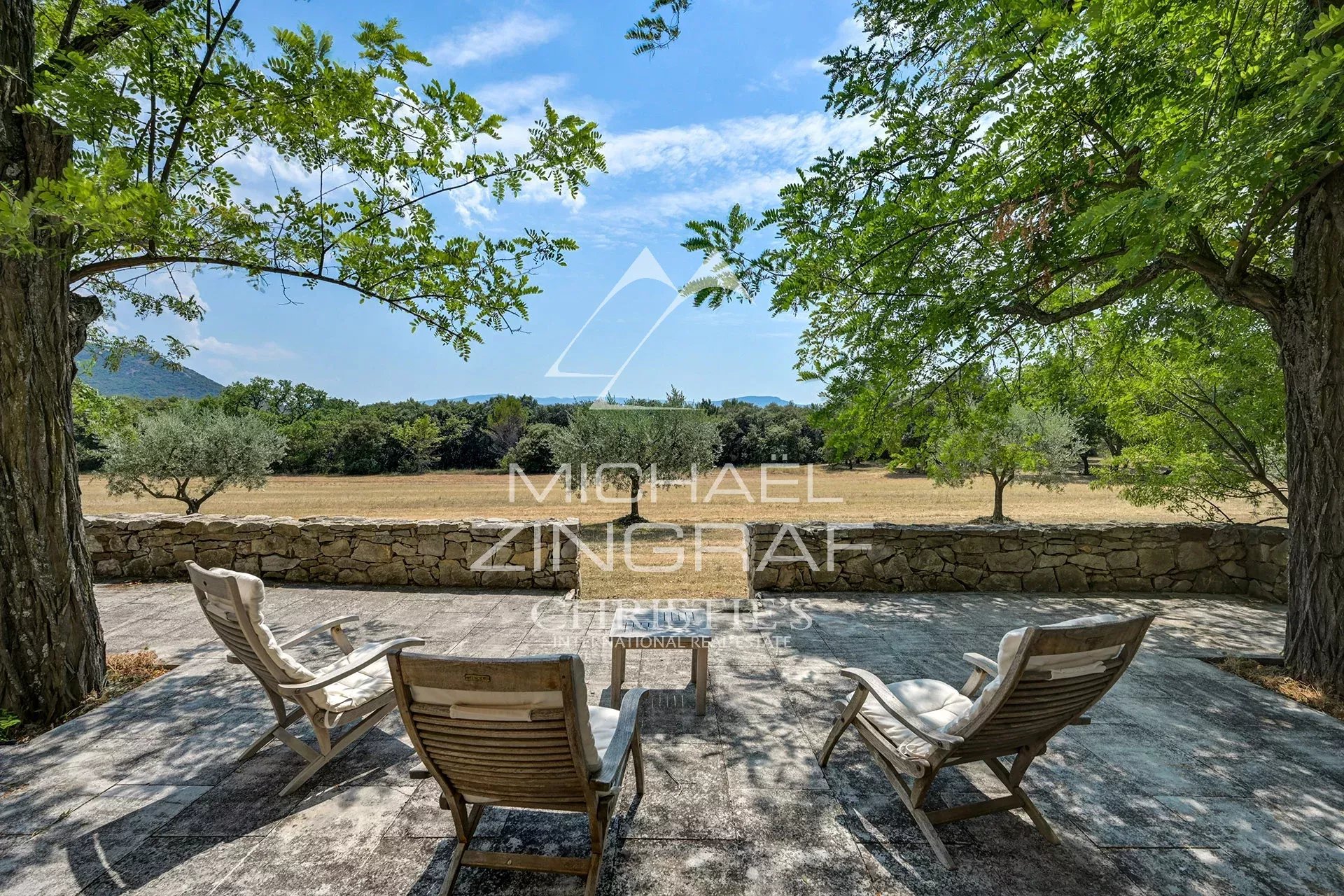 Terrace of a Provençal country house Terrace with sun loungers, overlooking a wooded estate and a clear sky.