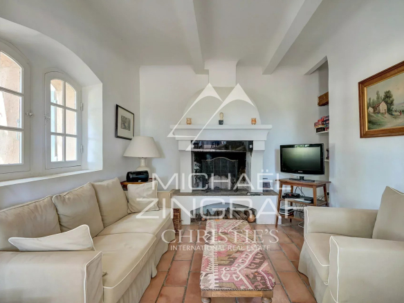 Interior of a 19th century Provençal country house with a bright living room and a fireplace.
