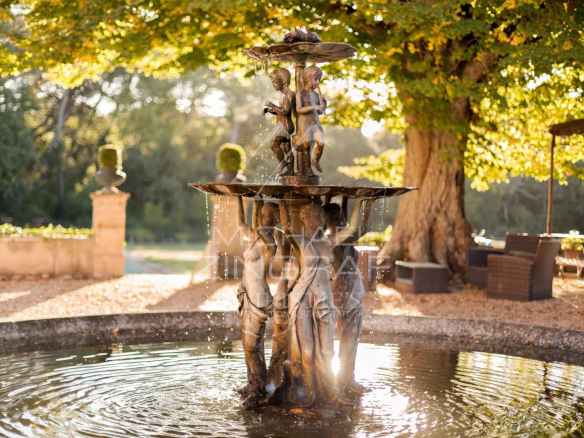 Fontaine en bronze avec des sculptures d'enfants au milieu d'un parc paysager à Aix-en-Provence.