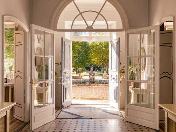 Intérieur d'une propriété aixoise avec portes ouvertes sur un parc paysager.