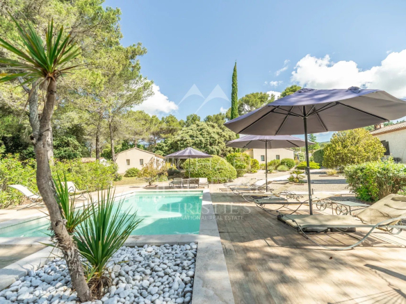 Piscine entourée de chaises longues et parasols dans une propriété avec gîtes à Puget.