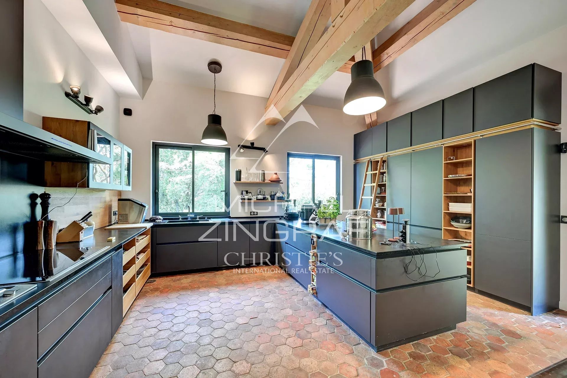 Cuisine d’une propriété d’exception à Aix-en-Provence Cuisine moderne et spacieuse avec îlot central et grandes fenêtres, éclairée par la lumière naturelle.