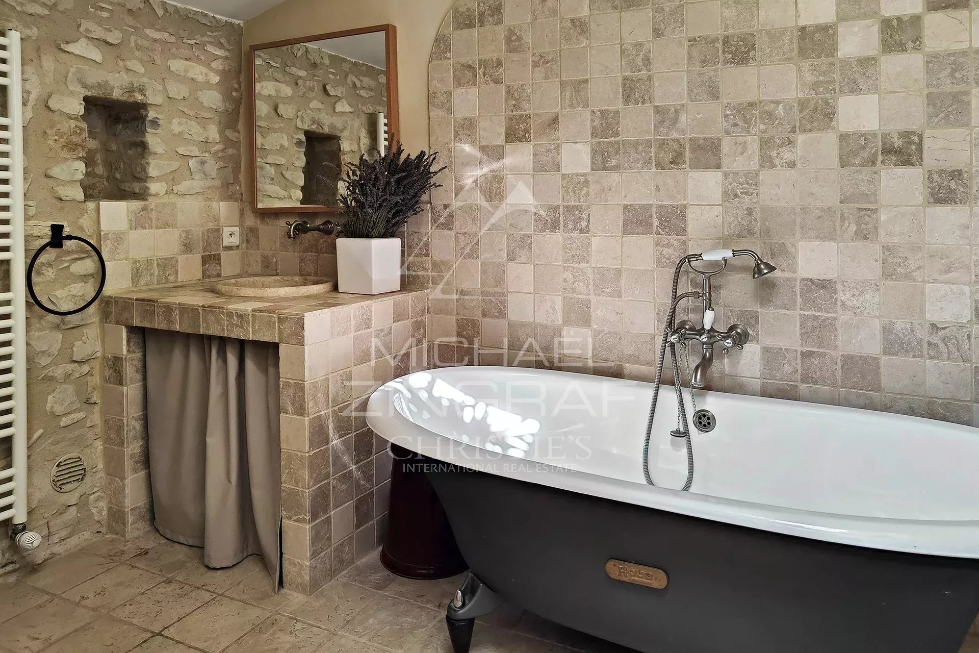 Bathroom in a renovated mill with freestanding bathtub and stone walls.