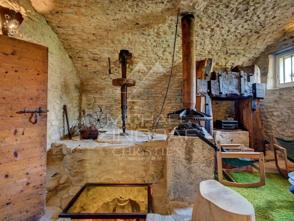 Interior of a renovated 17th-century mill with stone walls and antique equipment.